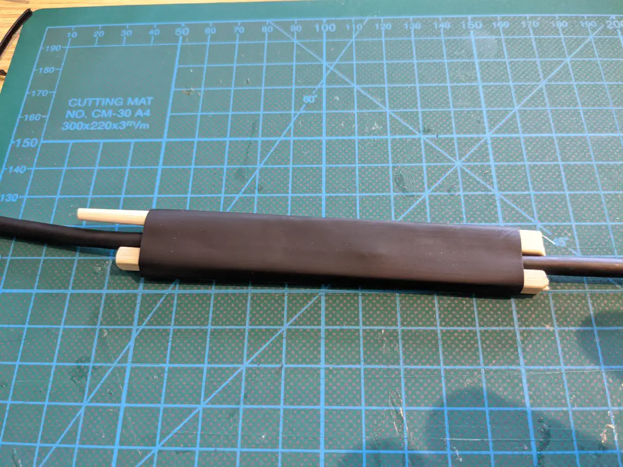The cable with chopsticks and heat shrink tubing applied